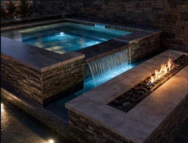 Custom hot tub and spa with stonework, lighting, and fire detail.