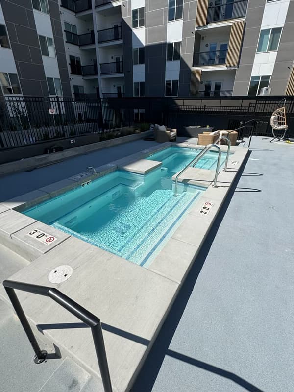 Finished spa with entry rails, steps, and seating at the Millcreek project.